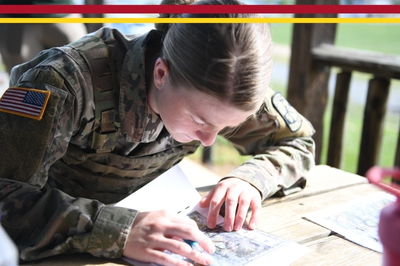 A female ROTC cadet studies maps during field training exercises at VMI.