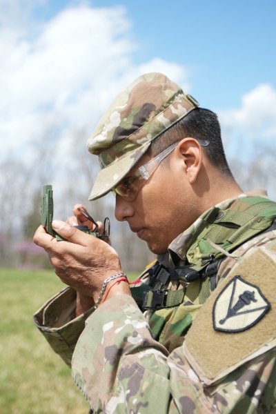 Cadet in NROTC training to be a Marine uses a compass during field training.