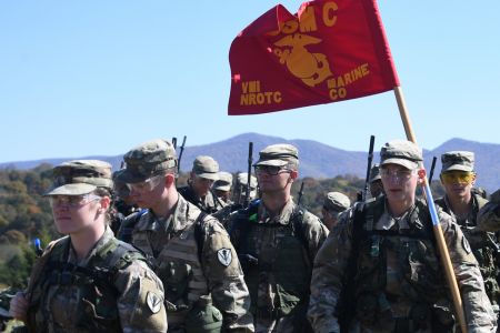 Marine-option cadets with Navy ROTC train in the field and carry a US Marine Corps flag.