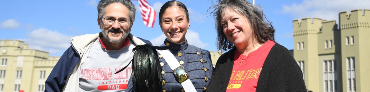 Female cadet poses for a photo with her parents who are wearing VMI shirts.