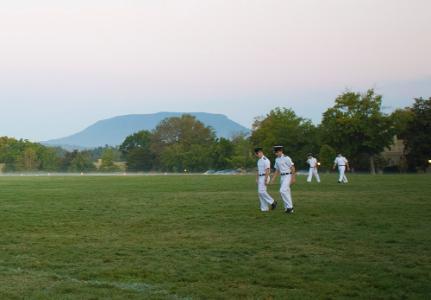 Cadets walk across the VMI Parade Ground at daybreak.