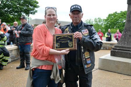 Tom Miller, spokesman for Run For The Wall, presents plaque to Samantha Marshall, widow of Lt. Col. Troy Marshall.-VMI Photo by Marianne Hause.