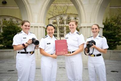Yearbook staff members posing with copy of The Bomb and cameras. Left to Right: Alexis Wade, Katie Feng, Christina Skaggs, Jessica Hankin