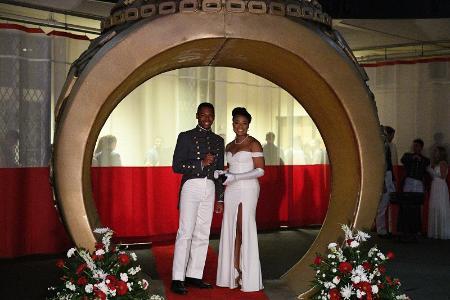 Cadet and date pose in oversized ring entrance at the dance.