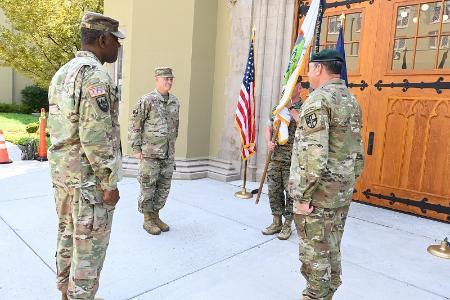 Maj. Gen. Cedric T. Wins ’85, Col. Lawrence Havird ’90, and Col. Adrian T. Bogart III ’81 stand at attention as Sgt. Maj. Tom Sowers holds the guidon.