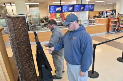 Department of Facilities Management staff members, Spencer Hulvey and Drake Sheets, use the kiosks in the PX to order and pay for their lunch.